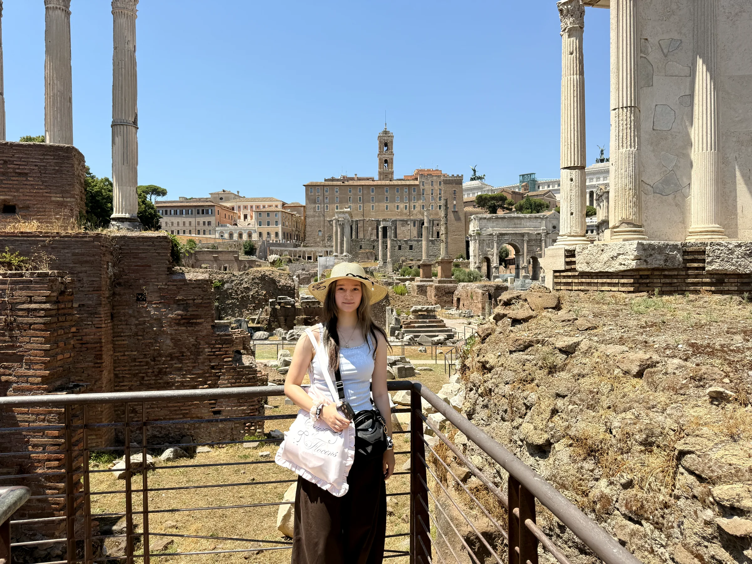 Alexia at a railing above the Roman Forum, columns and ruins behind her.