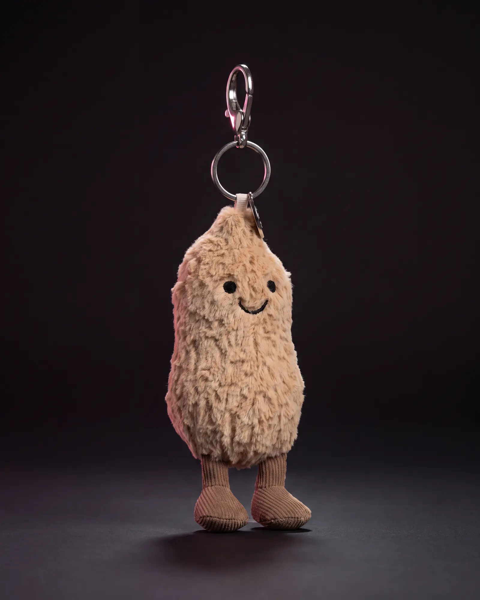 Amuseables Peanut Bag Charm on a dark studio background.
