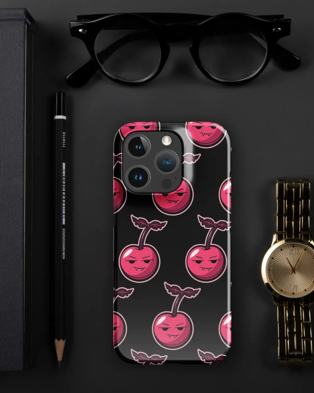Cherry Case on a dark desk beside a watch and glasses.